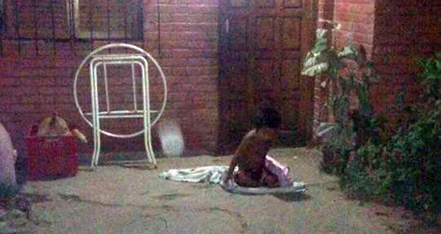 Nene durmiendo a la intemperie de noche y entre las mantas de los perros