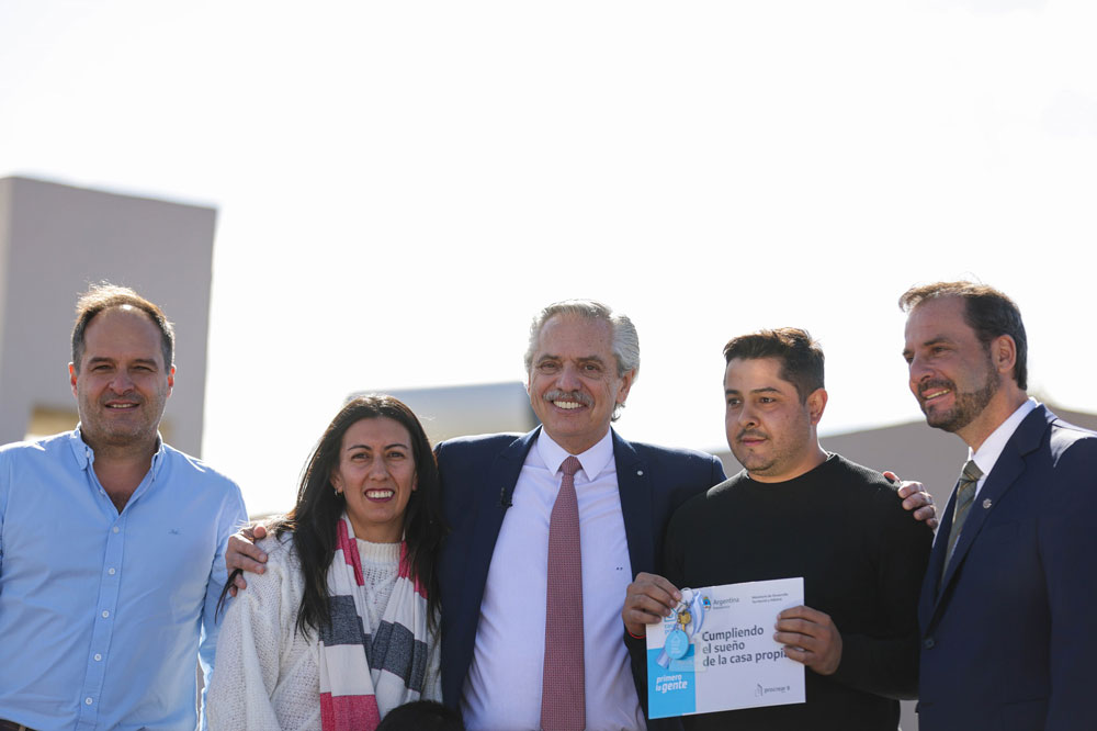 Alberto Fernández con funcionarios y una familia beneficiaria