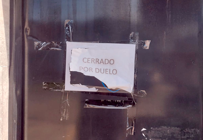Cartel "Cerrado por duelo" en la puerta de la concesionaria EW Automotores