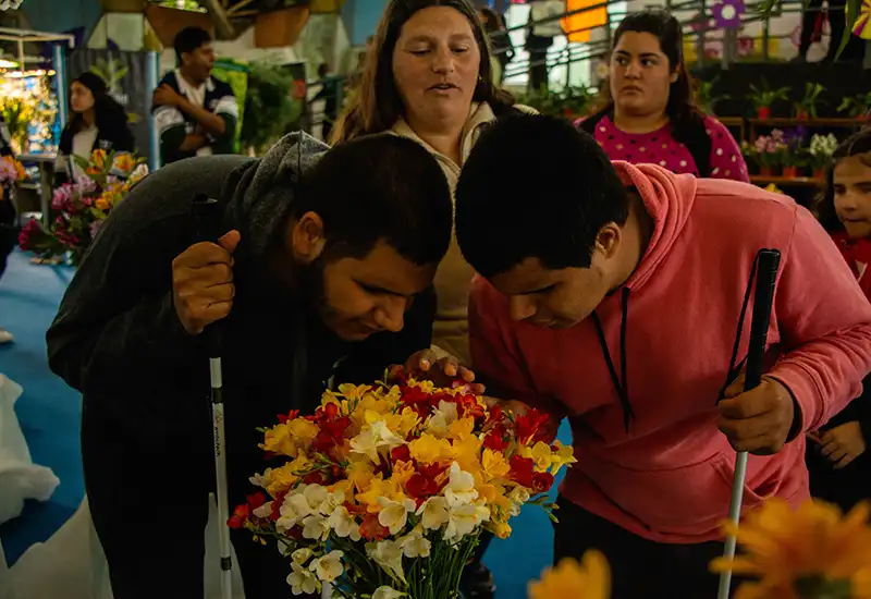 los visitantes disfrutan oliendo flores en un pabellón