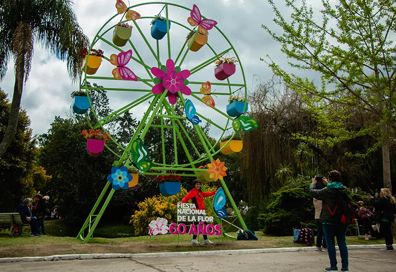 gente sacándose fotos en la rueda de maceteros colgantes de la Fiesta de la Flor