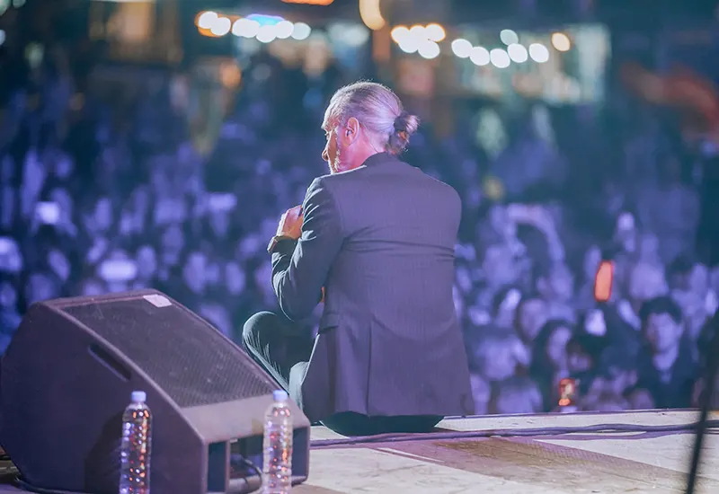 Manuel Wirzt, sentado en el escenario, habla con la gente