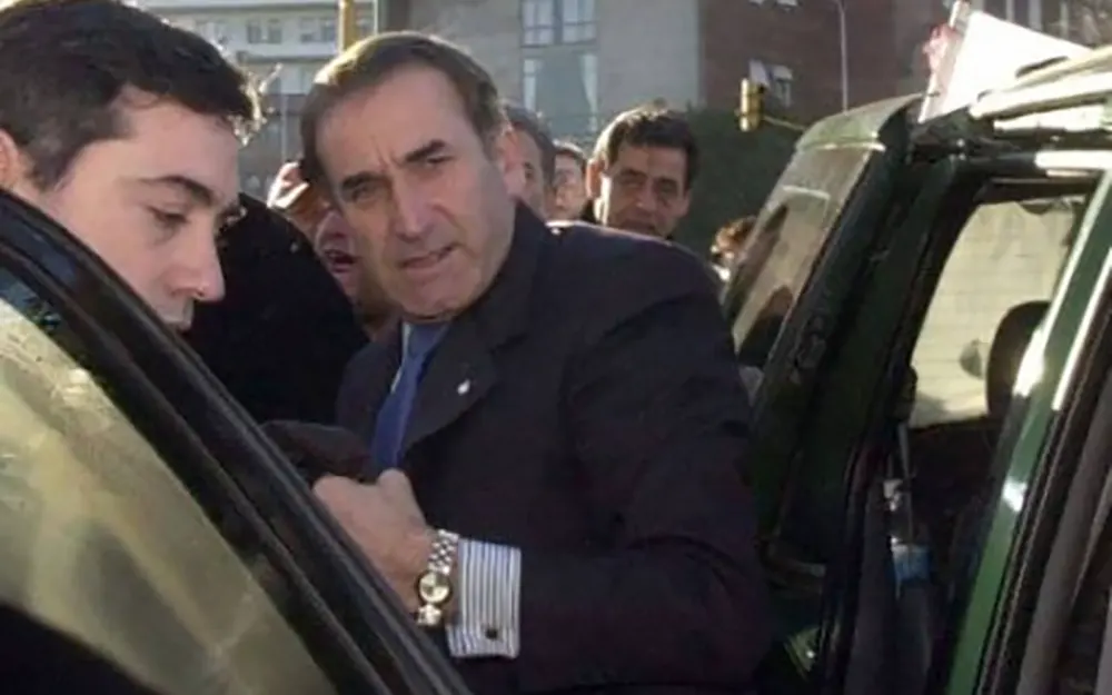 luis patti baja de un vehículo acompañado por varias personas