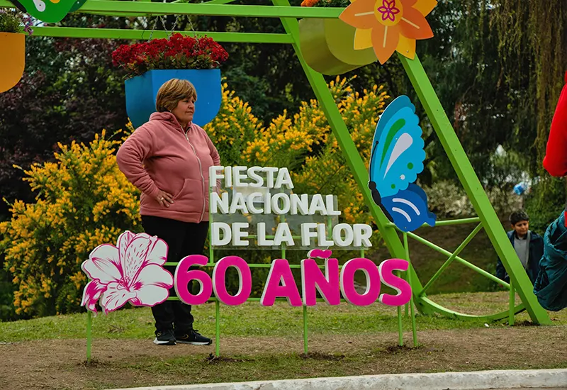 gente sacándose fotos en la rueda de maceteros colgantes de la Fiesta de la Flor
