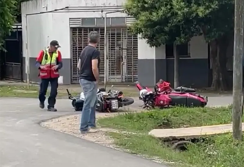 dos personas observan las motos tiradas sobre el asfalto