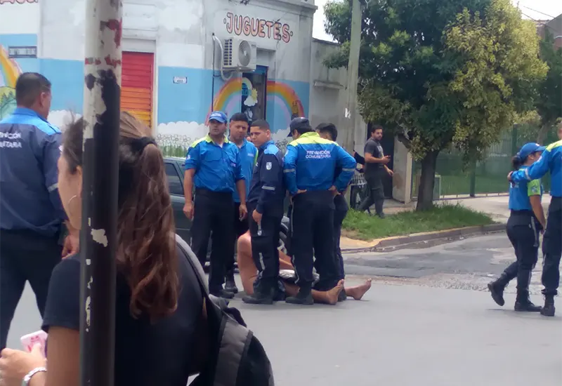 hombre desnudo en el asfalto, cubierto pro preventores comunitatios