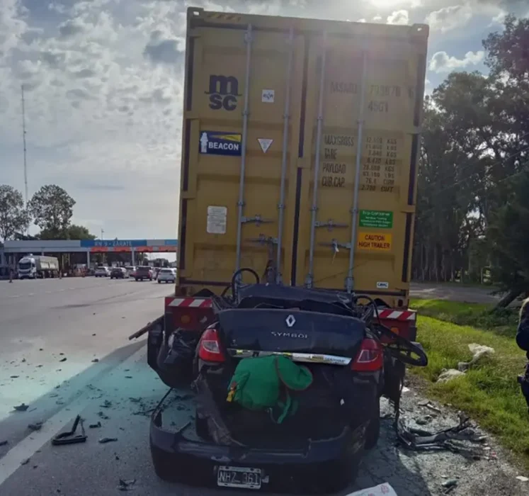 auto incrustado bajo un camión