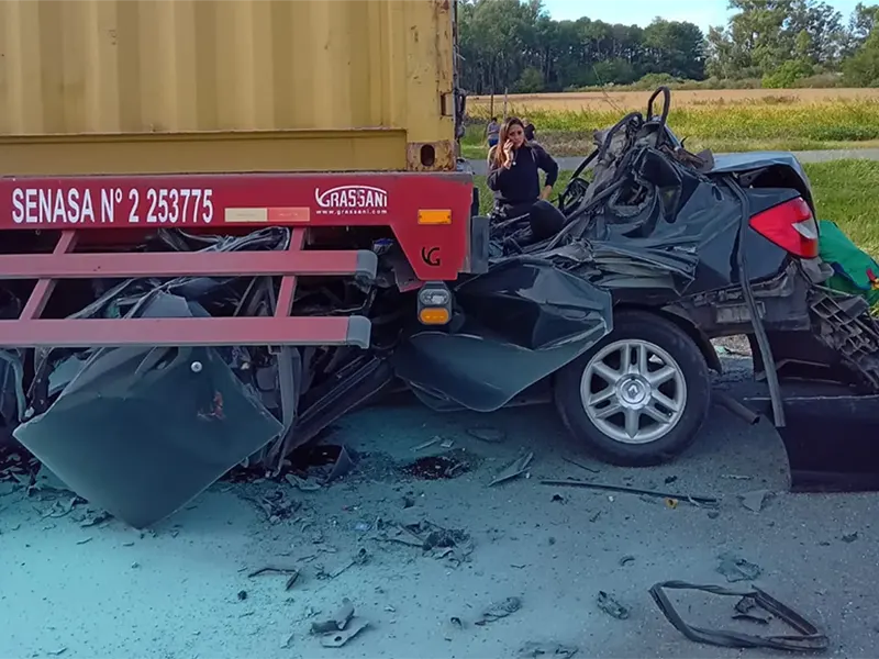 auto incrustado bajo un camión