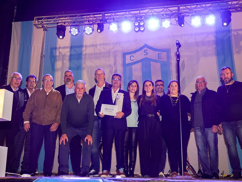 autoridades del club posan para la foto en el escenario