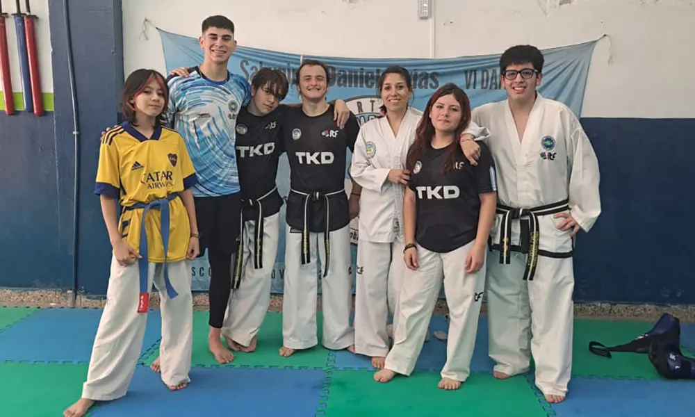 Alumnos del centro de artes marciales posando junto a su bandera