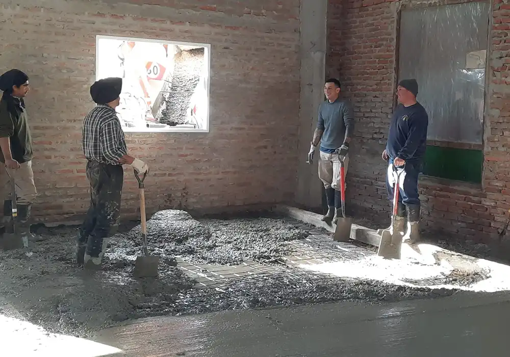 Bomberos colocando la mezcla del nuevo piso de concreto