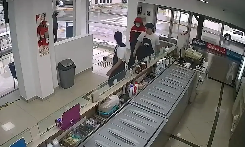 Uno de los delincuentes lleva a los empleados al baño durante el robo