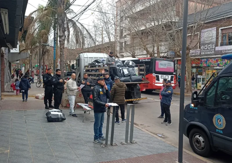 personal policial carga la mercadería incautada en la feria en un camión