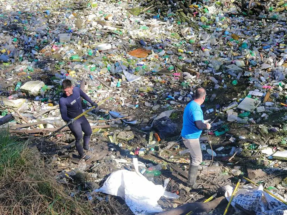 Vecinos de Escobar y miembros de organizaciones ambientalistas remueven enormes cantidades de basura de las aguas del cauce