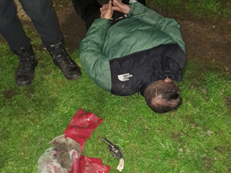 Uno de los detenidos por la policía está esposado en el piso.
