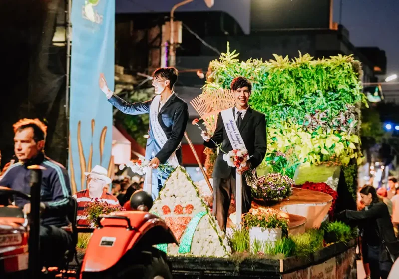 Dos de los embajadores de la Flor arriba de una carroza en el desfile de la Fiesta de la Flor