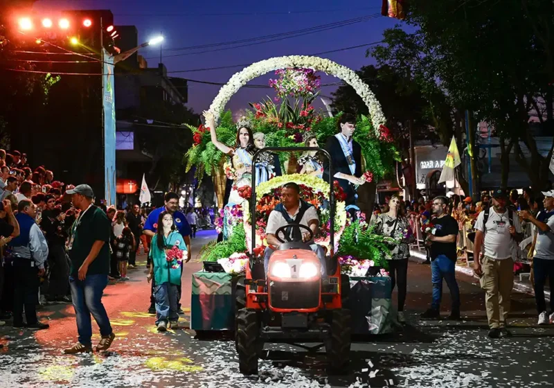 Carroza tirada por un pequeño tractor en el desfile de la fiesta de la flor