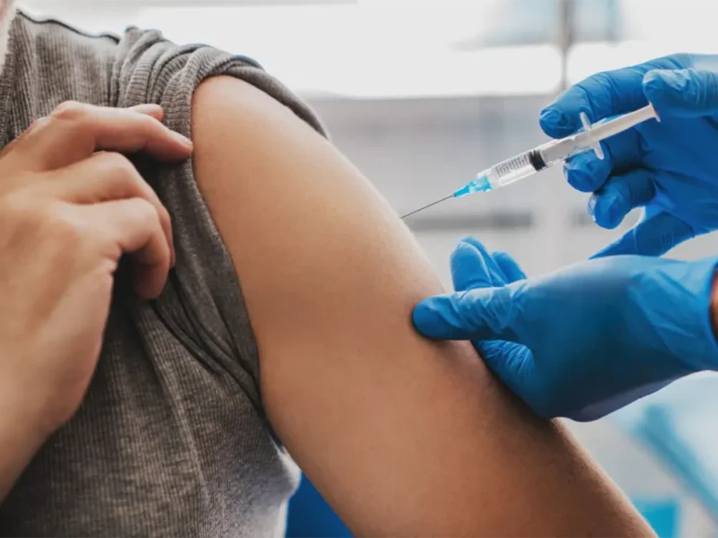 una persona le aplica a otra la vacuna contra el dengue