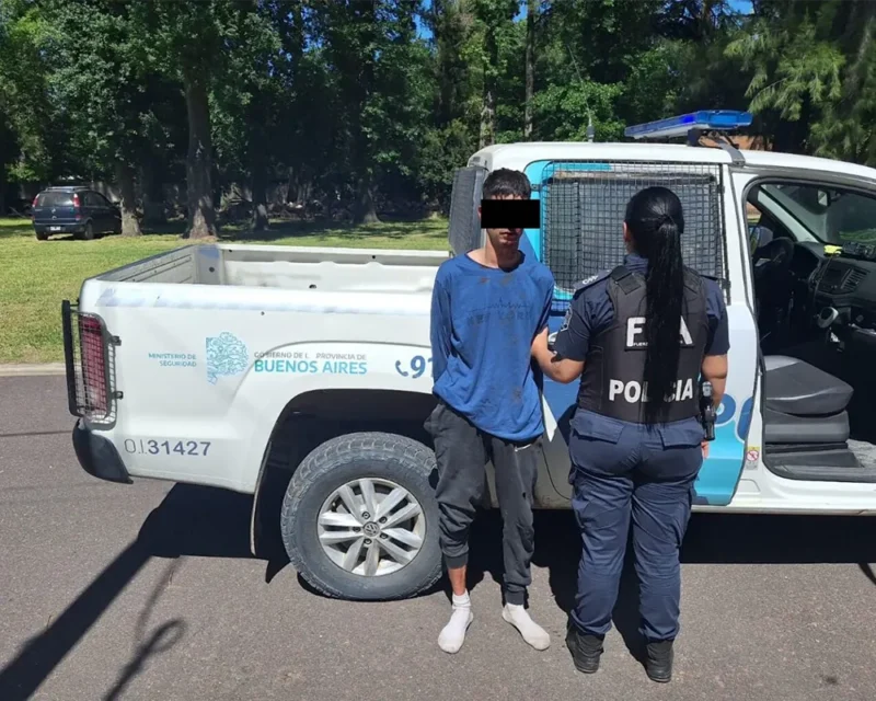 ladrón detenido al lado del patrullero