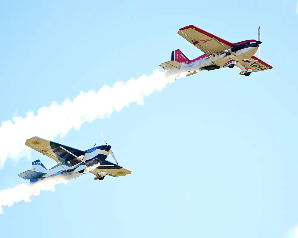 Avionetas surcando el cielo mientras dejan estelas de humo en la muestra Escobar Vuela