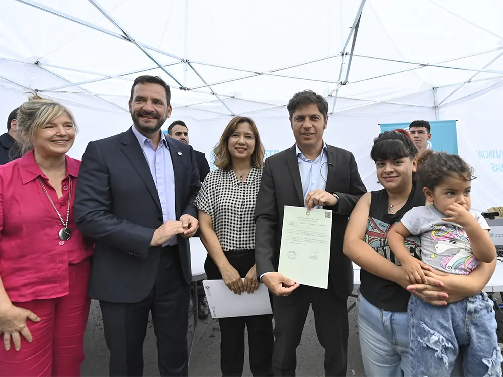 Kicillof, Sujarchuk y Alvarez Rodríguez junto a funcionaria y una madre con su hijo en brazos entregan partidas de nacimiento.