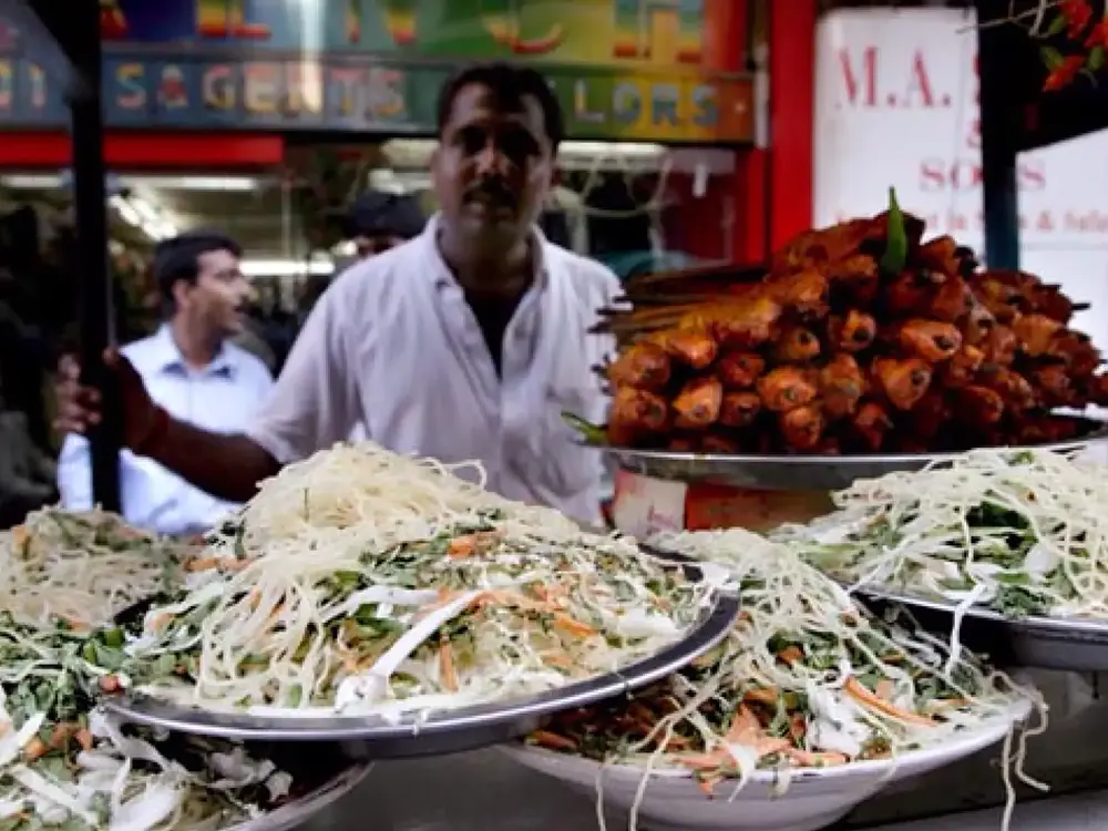 Un hombre en un puesto de comida callejera de la India