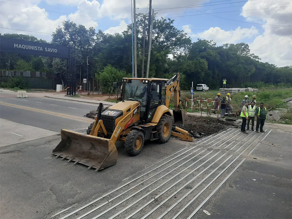 operarios junto a una topadora en el paso a nivel
