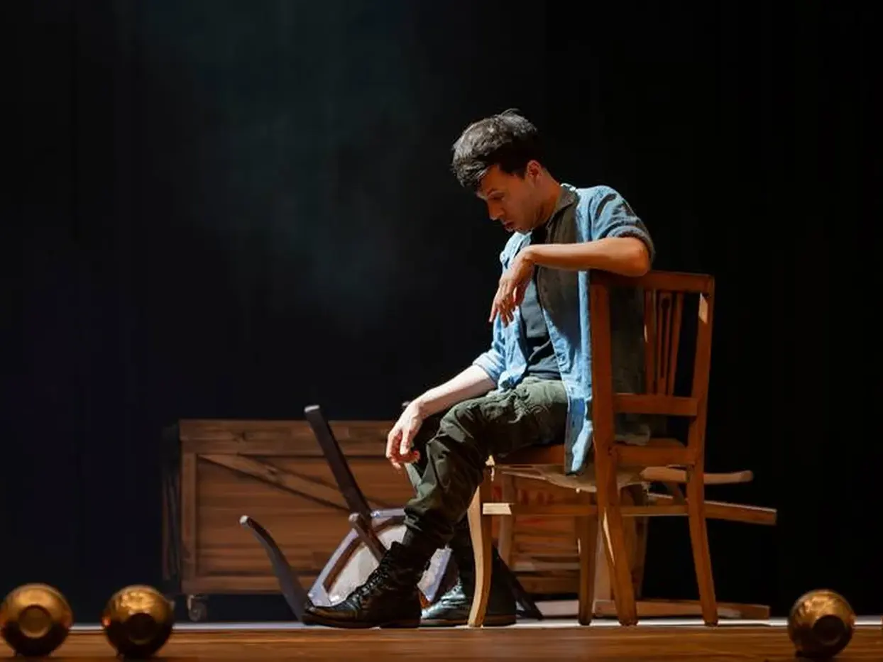 El actor Emiliano Dionisi sentado en el escenario.