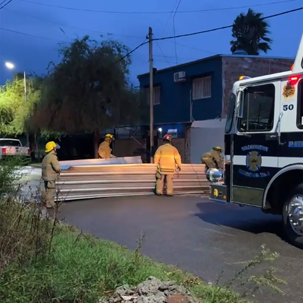 bomberos recogiendo chapas de techos que se volaron por los vientos