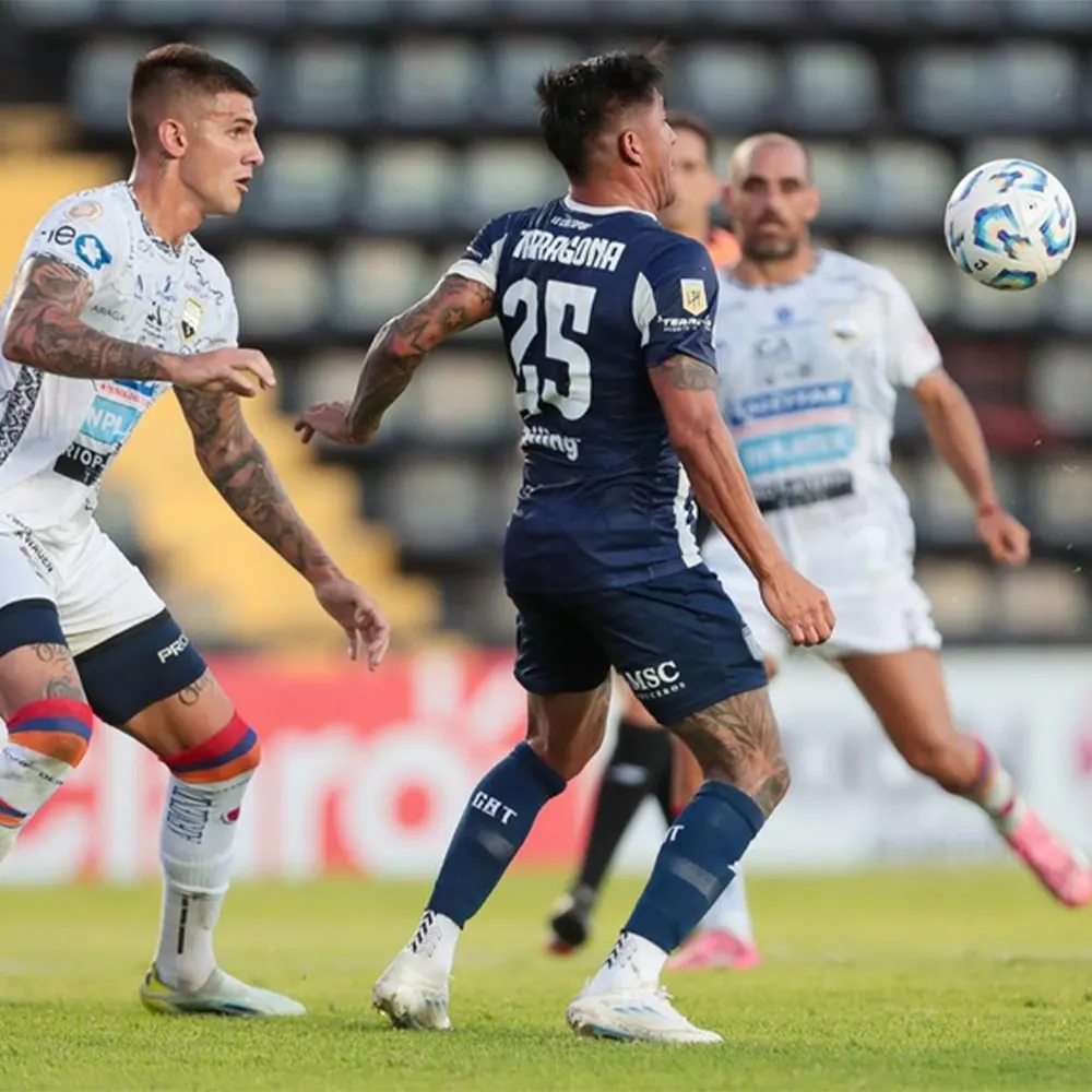 Jugadores de Armenio contar Talleres disputándose una pelota