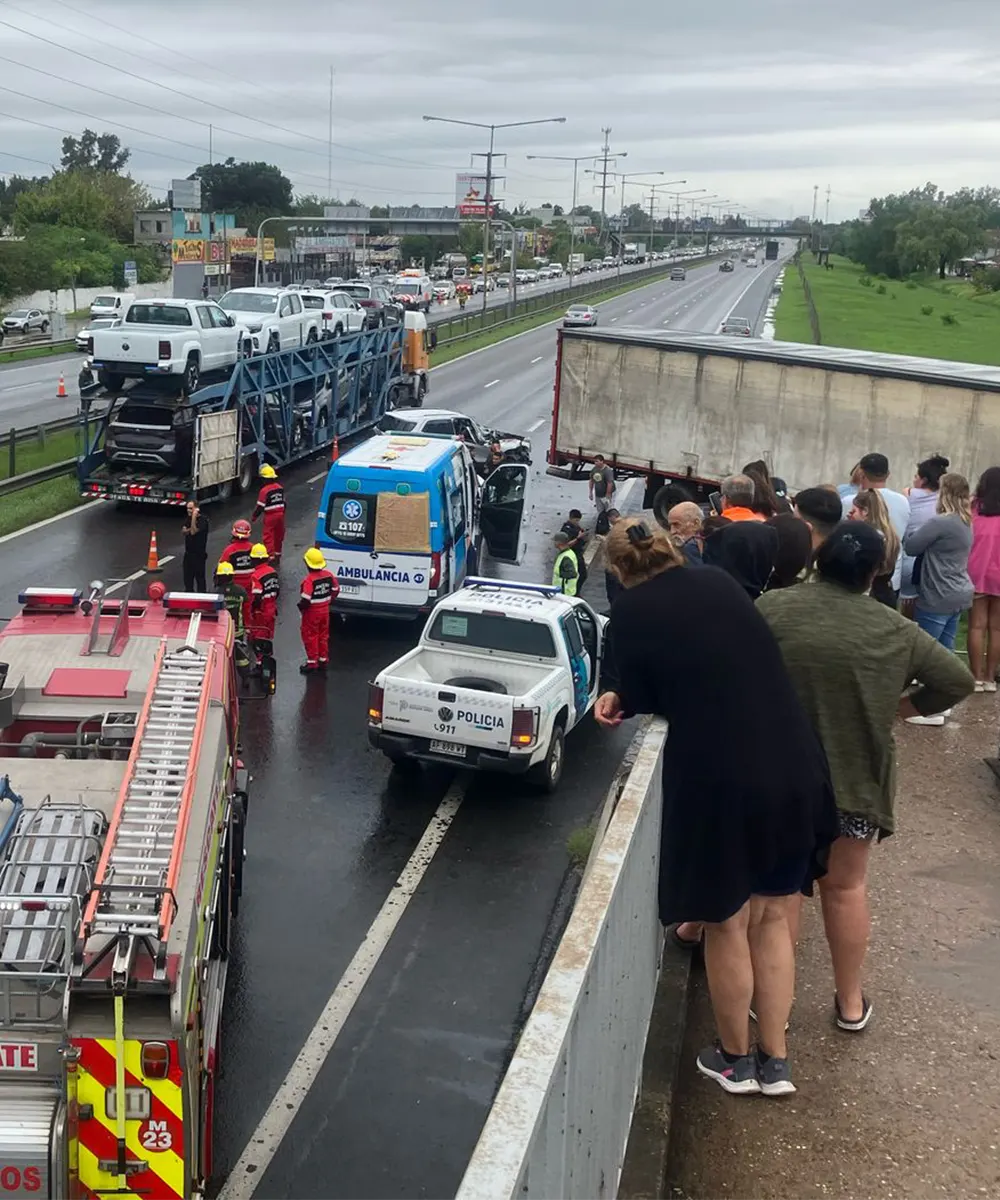 gente observando los vehículos chocados desde la pasarela