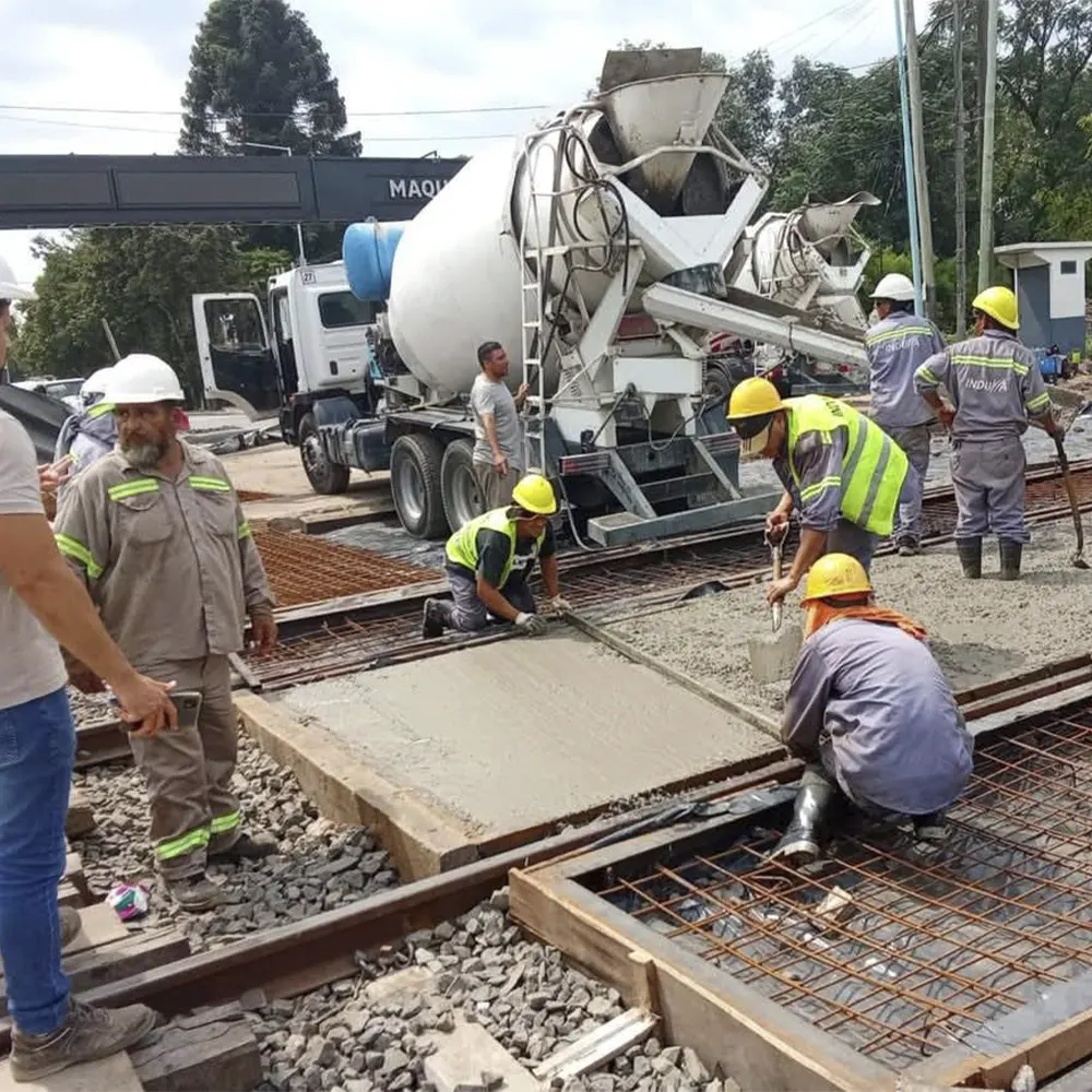 Trabajdores llenando la malla con concreto en el Nuevo paso a nivel