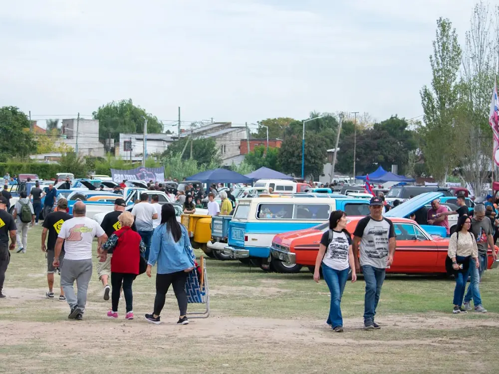 Gente recorriendo la exhibición de autos Chevrolet.