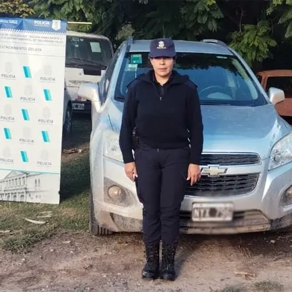 Una agente de Policía delante de la camioneta recuperada