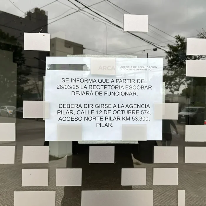 Cartel que indica que los que necesiten hacer trámites en ARCA deben dirigirse a las oficinas en Pilar