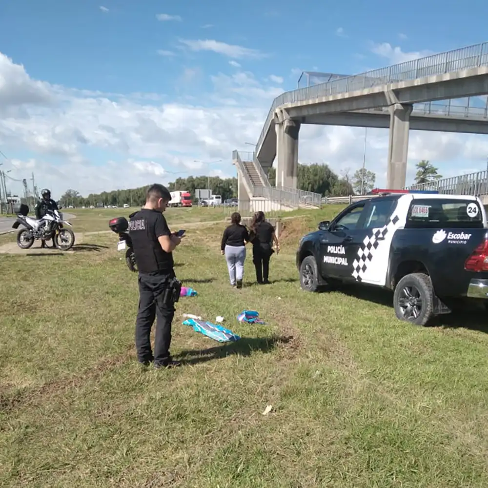 policia escribiendo el acta mientras una mujer policia lleva a la victima de la mano hacia el patrullero