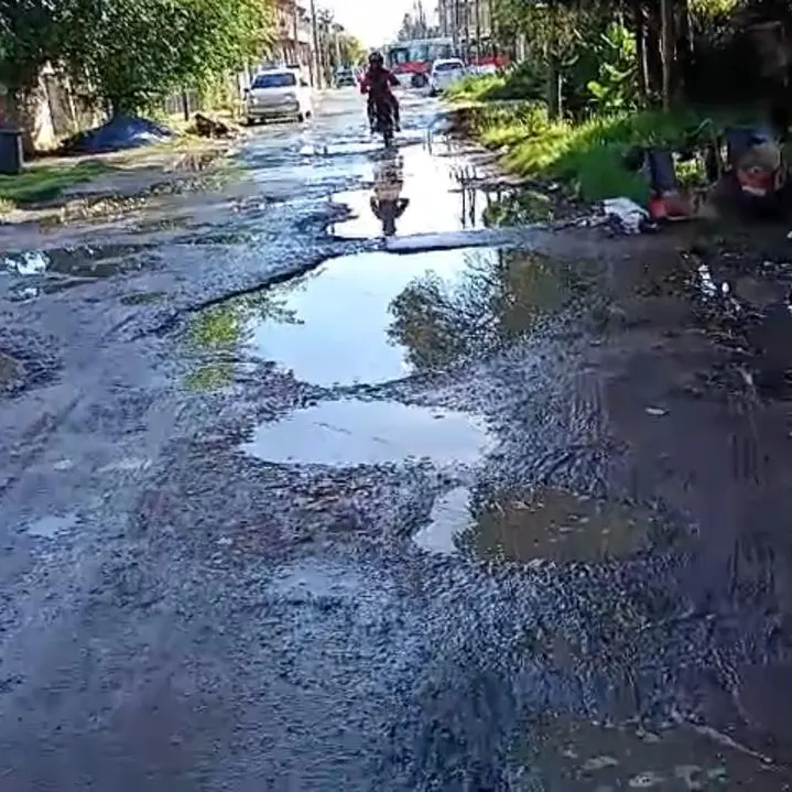 calle llena de baches, agua y barro