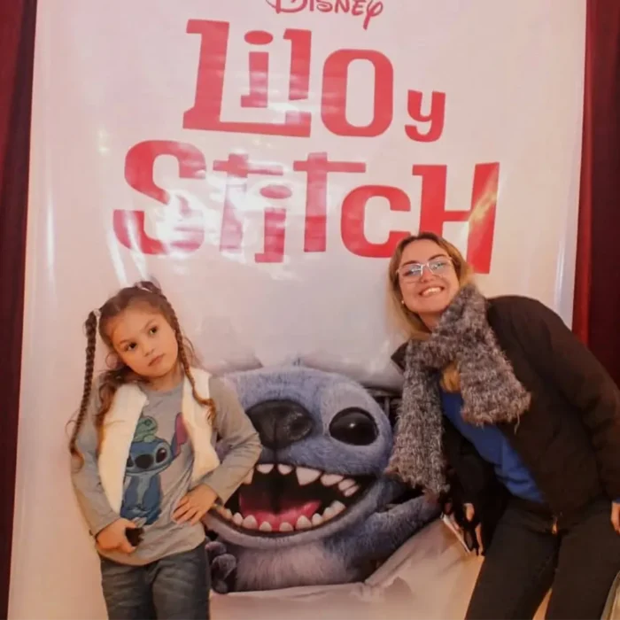 Madre e hija posan junto al banner de la película