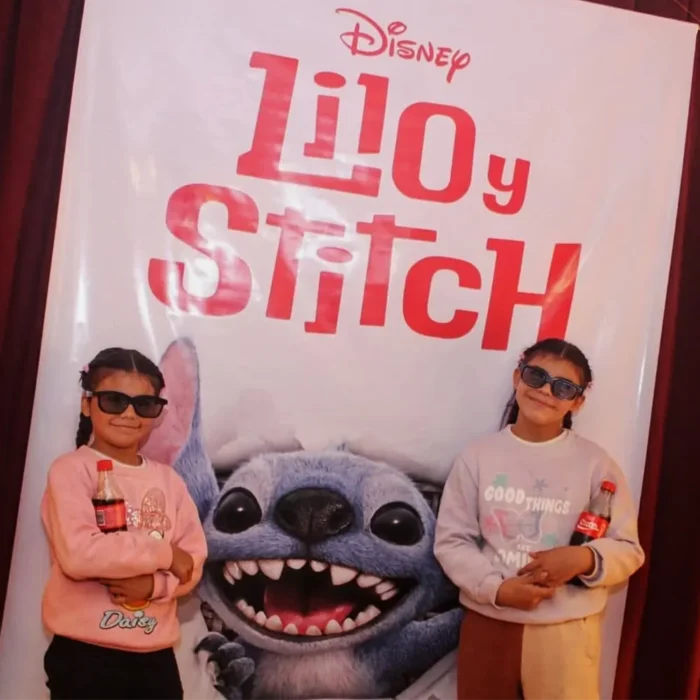 Niños emocionados lucen sus gafas 3D junto al banner de Lilo & Stitch