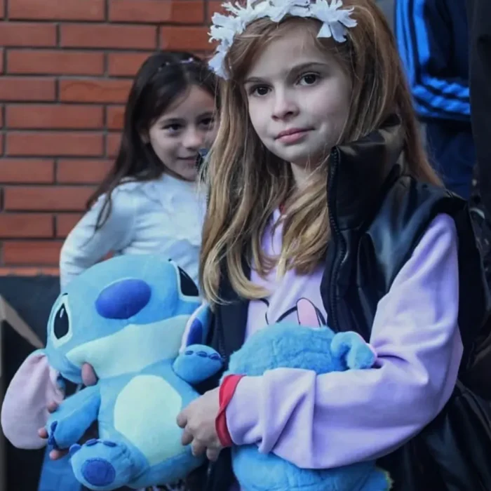 Una niña abrazando su peluche de Stitch.