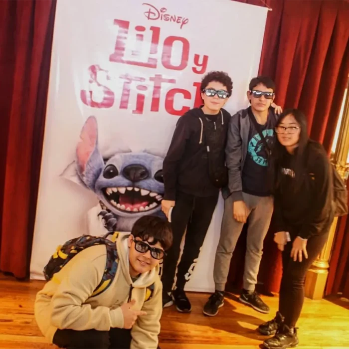 Niños fotografiándose junto al banner de la película