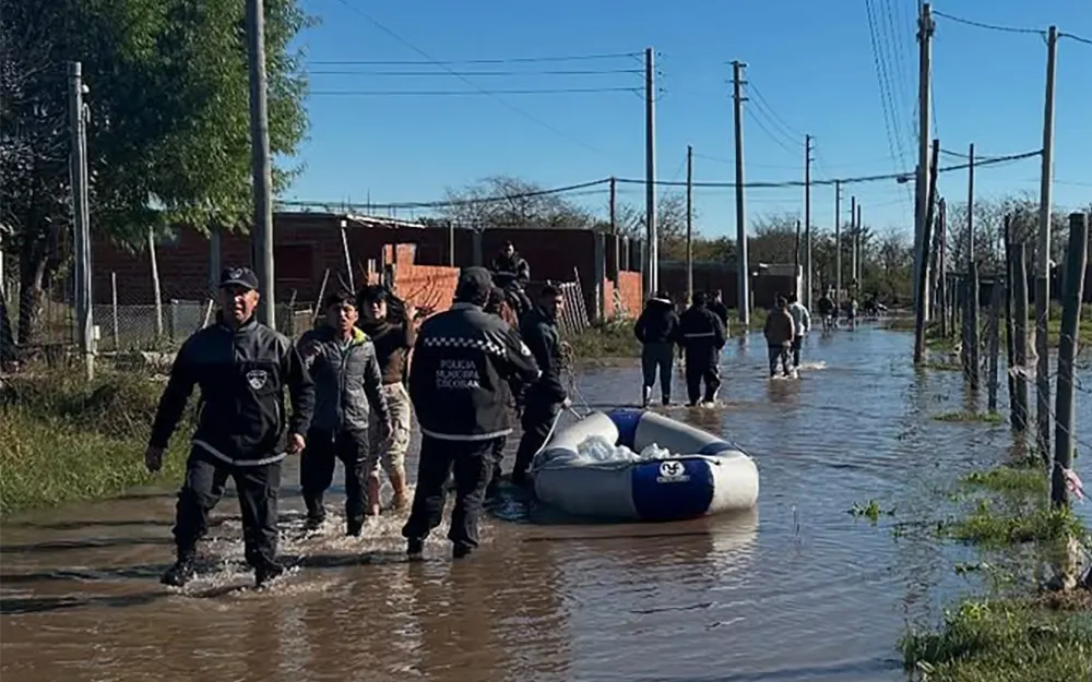 TEMPORAL 1 Efectivos recorren las zonas inundadas caminando con el agua hasta los tobillos y trasladan una lancha.