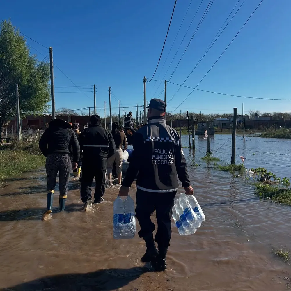Policías y vecinos colaboran en las tareas de asistencia a los damnificados por el temporal.
