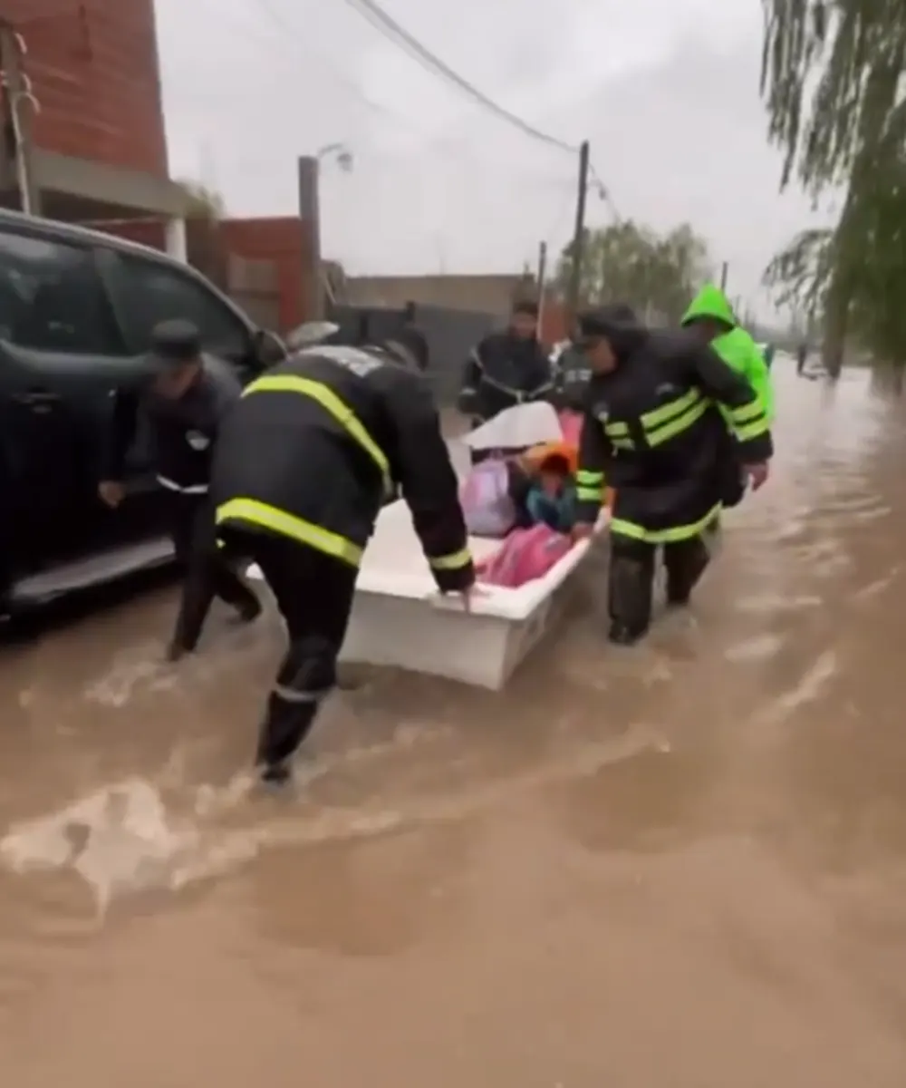 Personal de Defensa Civil evacuando gente en Maquinista Savio