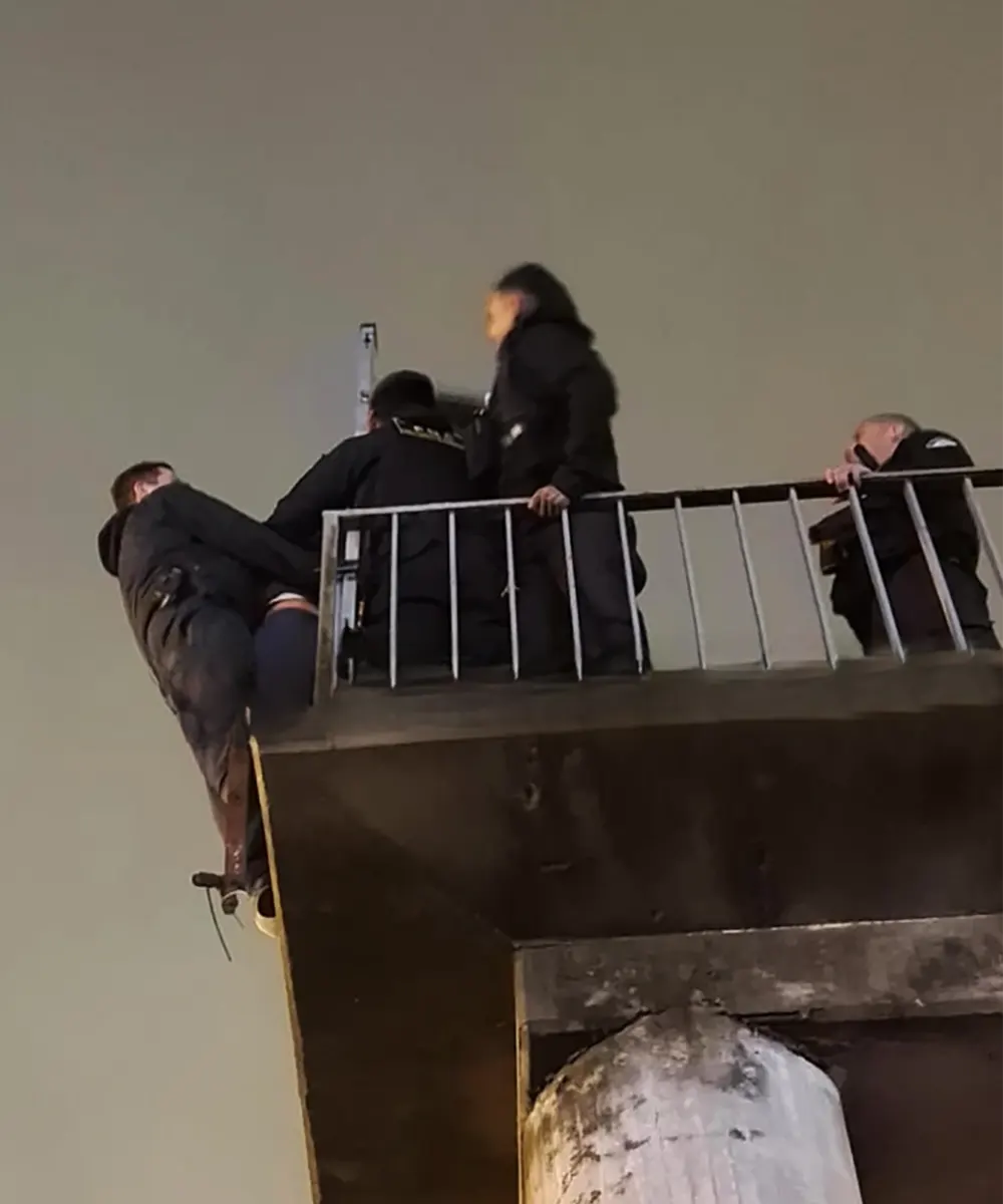 Efectivos policiales contienen a la mujer para evitar que se arroje del puente peatonal