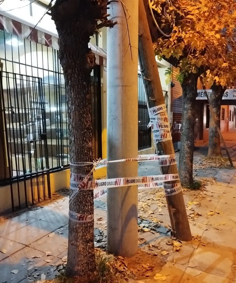 Poste inclinado envuelto en cintas de peligro