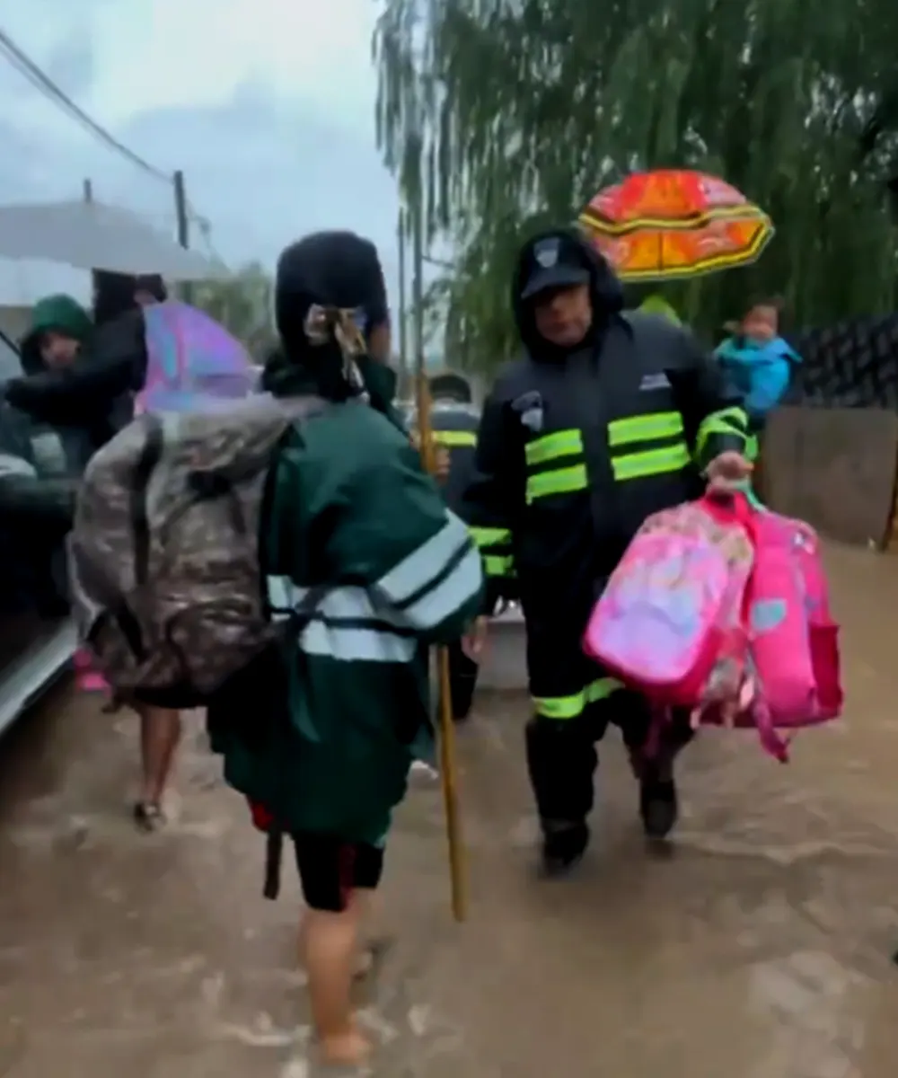 Personal de Defensa Civil evacuando gente en Maquinista Savio