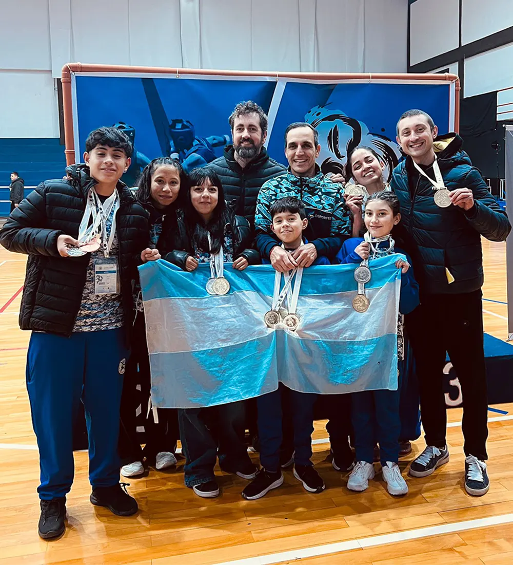 Alumnos de wushu con medallas y su entrenador