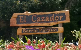 Cartel de entrada al barrio El Cazador trabajado en madera