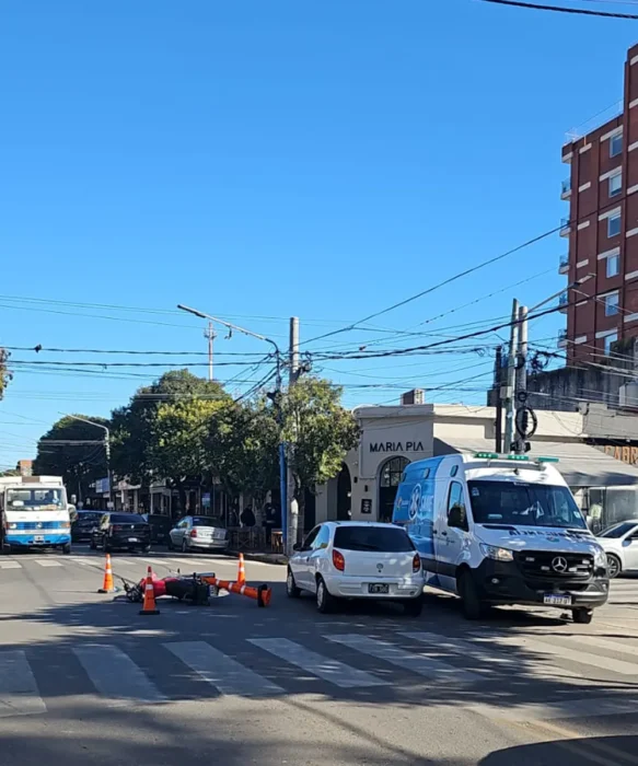 Moto tirada en el asfalto y ambulancia del SAME